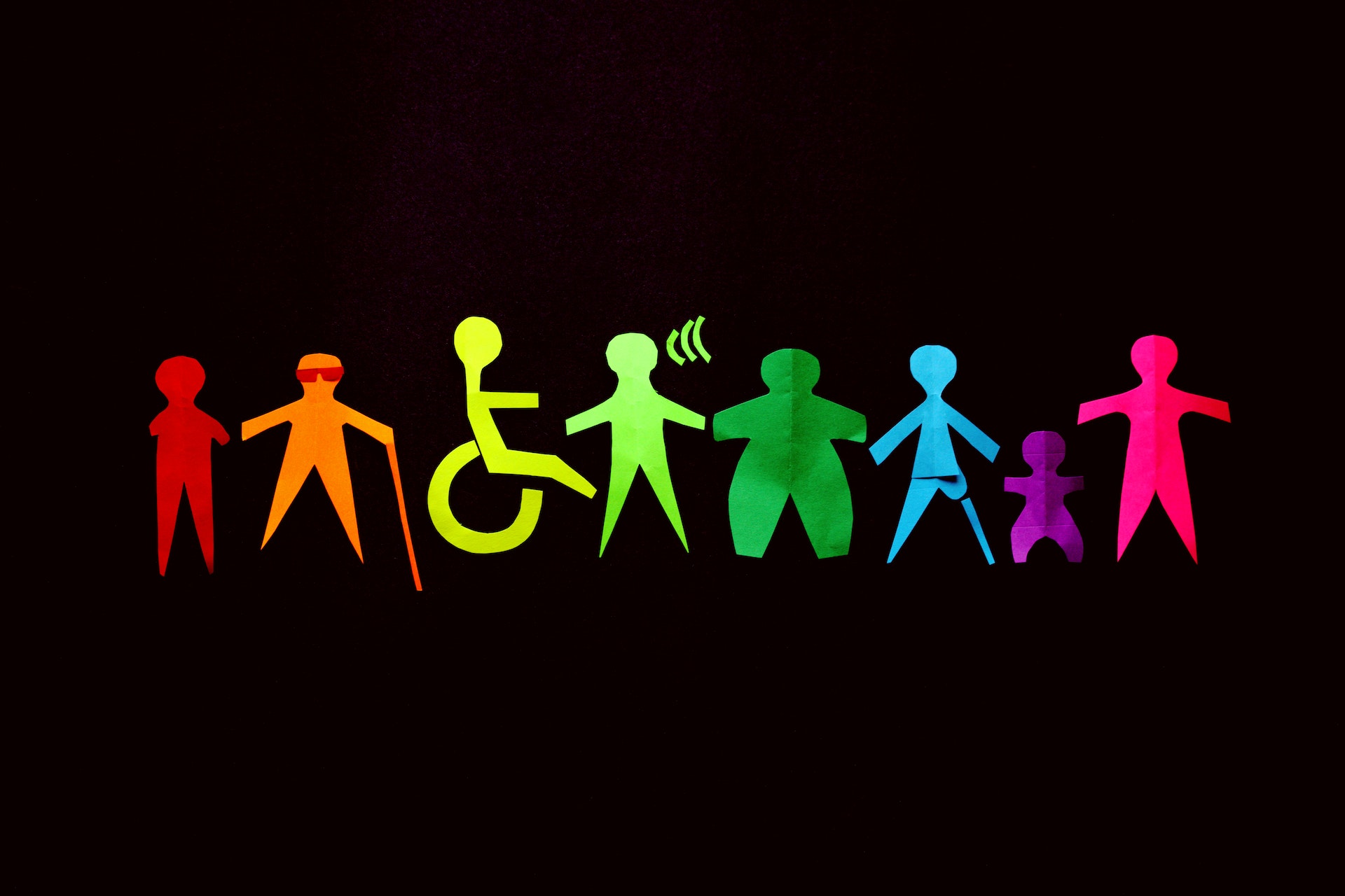 Illustration of figure characters standing together in a line of unity to highlight accessibility and inclusivity.